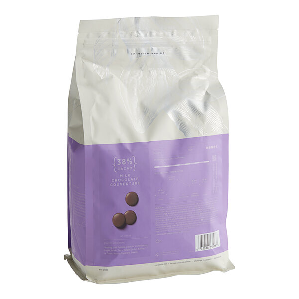 A white and purple bag of Guittard Soleil d'Or milk chocolate wafers.