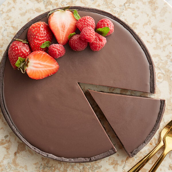 A chocolate cake with a slice missing and strawberries on top.