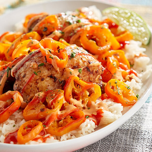 A plate of rice, chicken, and Goya Los Andes Aji Amarillo Yellow Hot Peppers.