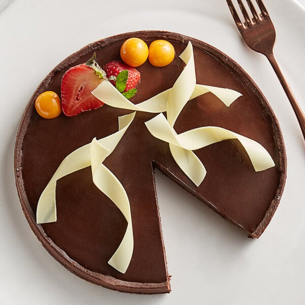 A slice of chocolate cake with strawberries and white chocolate on a white plate.