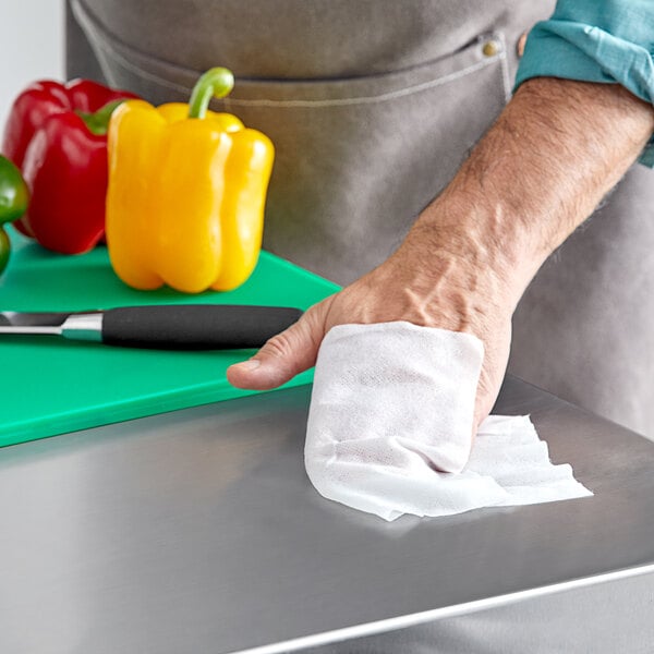 A person using WipesPlus to clean a food surface.