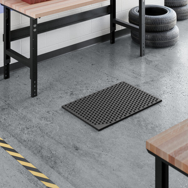 A black heavy-duty rubber anti-fatigue floor mat with a diamond pattern and straight edges, measuring 2 feet by 3 feet.