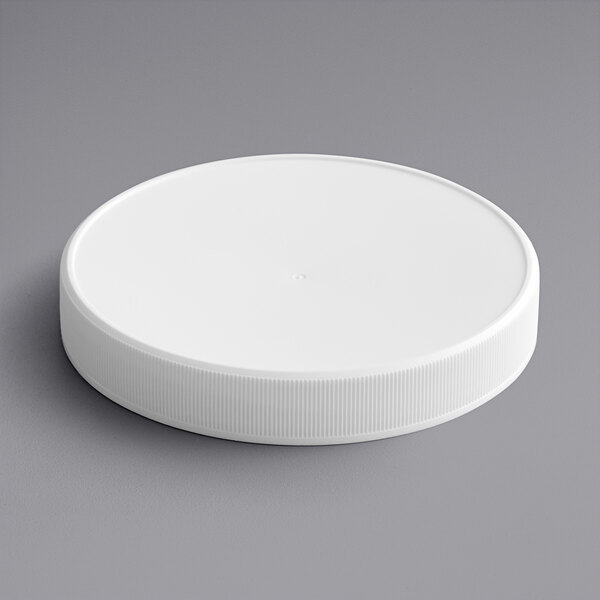 A 120/400 white plastic cap with foam liner on a gray surface.