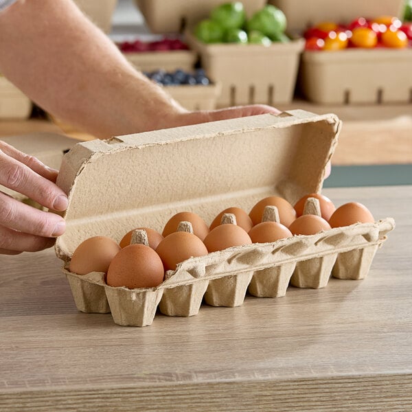 A person holding a Choice Pulp egg carton full of eggs.