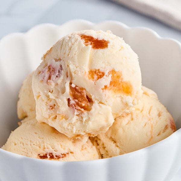 A scoop of Tillamook Peaches and Cream ice cream in a bowl.