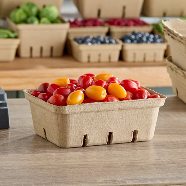 A rectangular pulp produce basket filled with red and yellow grape tomatoes.