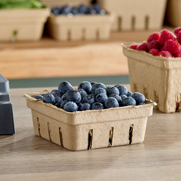 A row of Choice produce baskets filled with blueberries and raspberries.