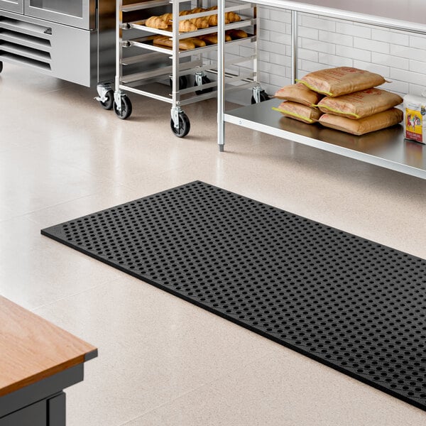 A heavy-duty black rubber anti-fatigue floor mat with a diamond pattern and straight edges, measuring 3 feet by 10 feet.