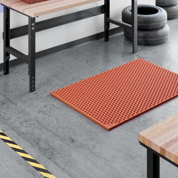 A heavy-duty red rubber anti-fatigue floor mat with a diamond pattern and straight edges, designed to be grease-resistant.