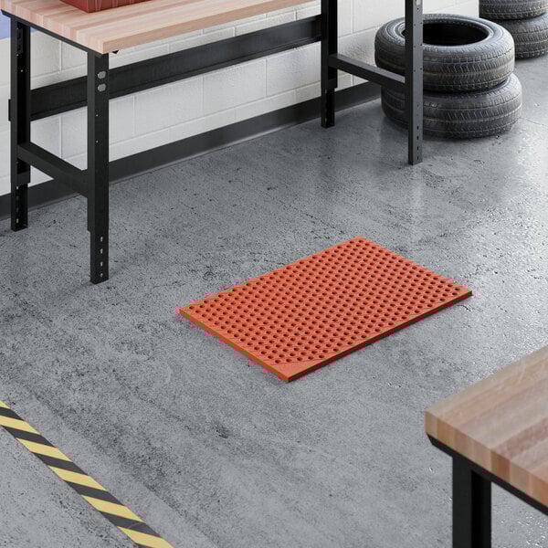 A red heavy-duty rubber anti-fatigue floor mat with a diamond pattern and straight edges, designed to be grease-resistant.