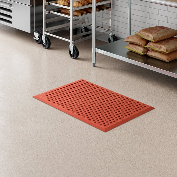 A red heavy-duty rubber anti-fatigue floor mat with a diamond pattern and beveled edge, designed for grease resistance.