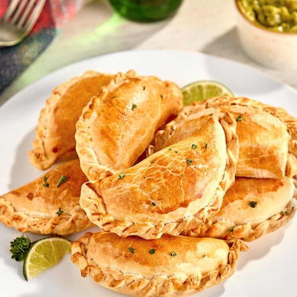 A plate of White Toque ready-to-bake empanada dough discs with baked empanadas.