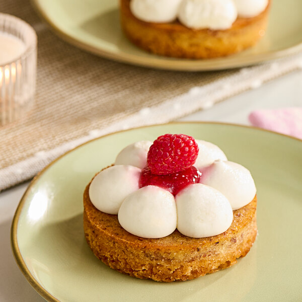 Two White Toque gluten-free cheese and raspberry tartlets with raspberries on top.