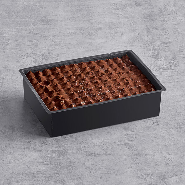 A black rectangular container with a white rectangular label holding tiramisu.