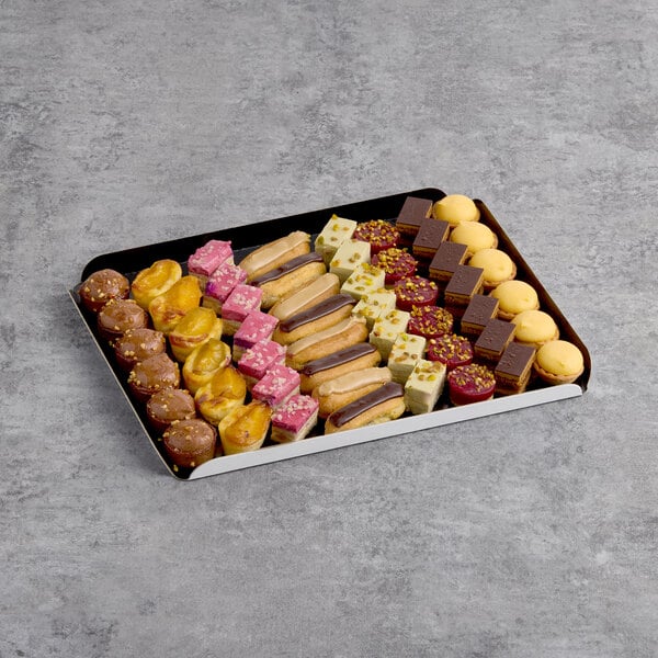 A White Toque Traditional Petits Fours assortment on a table in a bakery display.