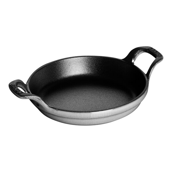 A close-up of a graphite gray Staub enameled cast iron pan with two handles.