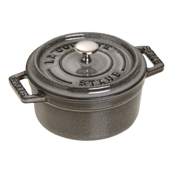 A graphite gray Staub mini enameled cast iron Dutch oven with a lid.