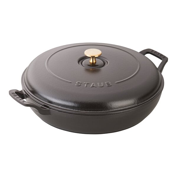 A black round Staub cast iron pot with a gold knob and lid.