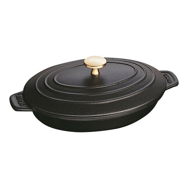 A black enameled cast iron oval baking dish with a lid.