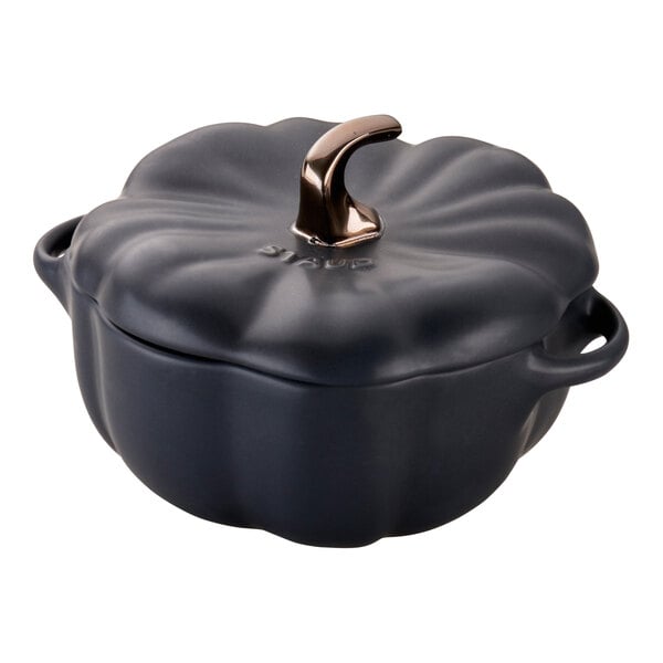 A black ceramic Staub pumpkin mini Dutch oven with a handle.