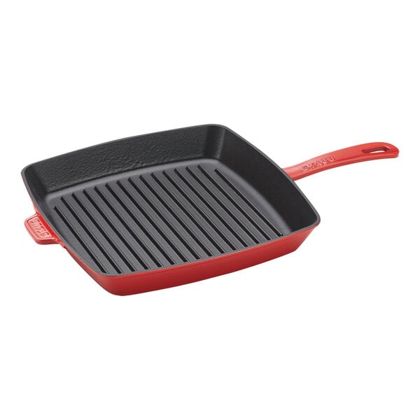 A Staub cherry red enameled cast iron square grill pan with a handle.