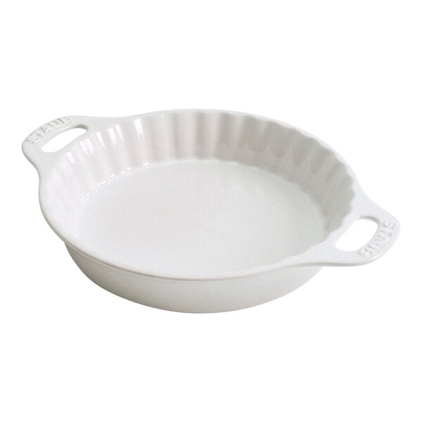 A white round baking dish with a handle.
