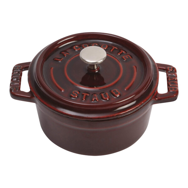 A red Staub mini Dutch oven with a lid and handle.
