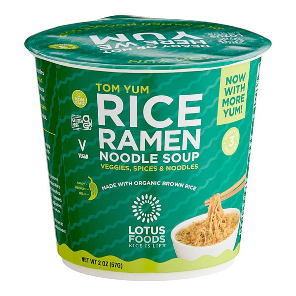 A green and white Lotus Foods container of Tom Yum rice ramen noodles with a blue label and a lid.