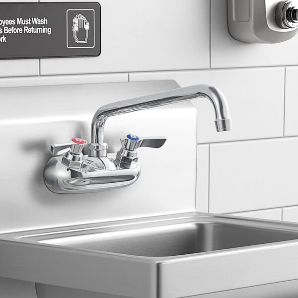 A Krowne Silver Series wall-mount faucet with lever handles and a 10" swing nozzle above a stainless steel sink.