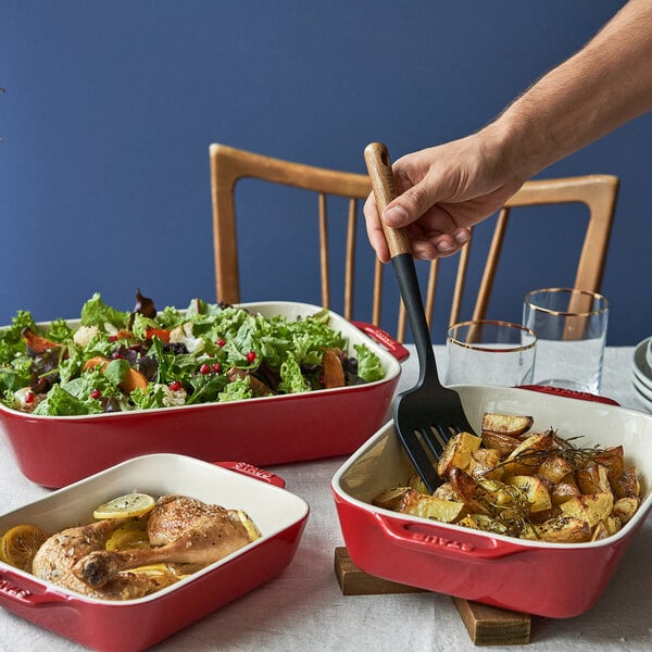 A red and white Staub rectangular baking dish with food in it.