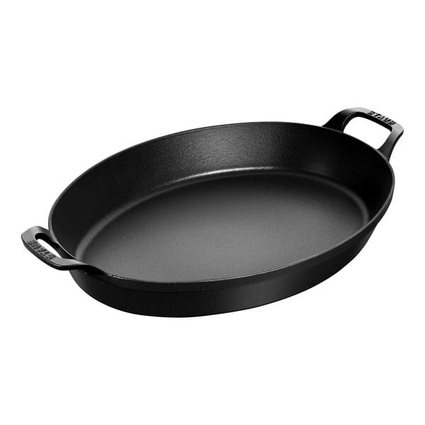 A black enameled cast iron oval pan with two handles.