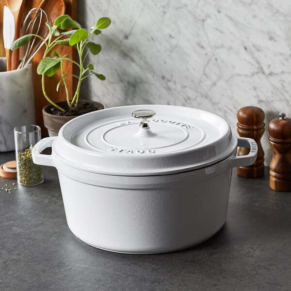 A white Staub enameled cast iron pot with a lid.
