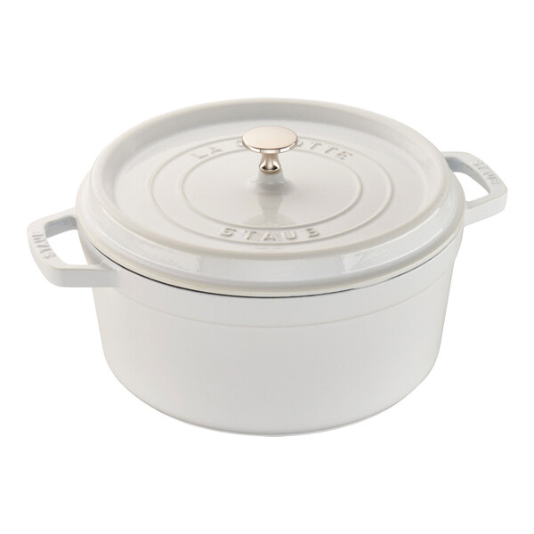 A white Staub enameled cast iron Dutch oven with a lid.
