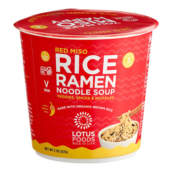 A red container of Lotus Foods Red Miso Rice Ramen with a white label and yellow lid filled with noodles.