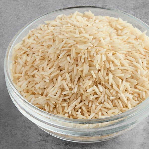 A bowl of Lotus Foods long grain white Basmati rice on a gray surface.