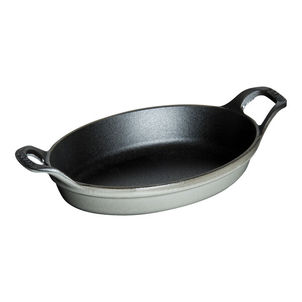 A graphite gray oval Staub enameled cast iron dish with two handles.