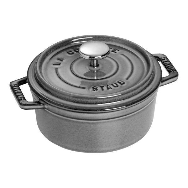 A graphite gray Staub enameled cast iron mini Dutch oven with a lid.