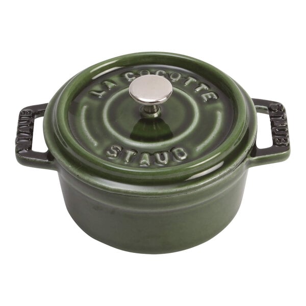 A green Staub enameled cast iron mini Dutch oven with a lid.