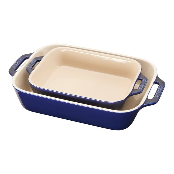 A stack of blue and white rectangular Staub ceramic baking dishes.