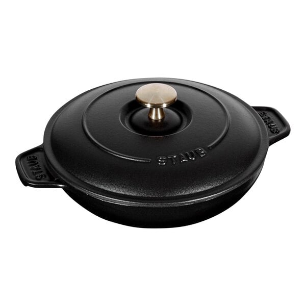 A black enameled cast iron round gratin/roasting dish with a lid and brass knob.