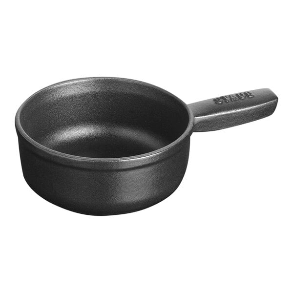 A black Staub enameled cast iron fondue pot with a handle.