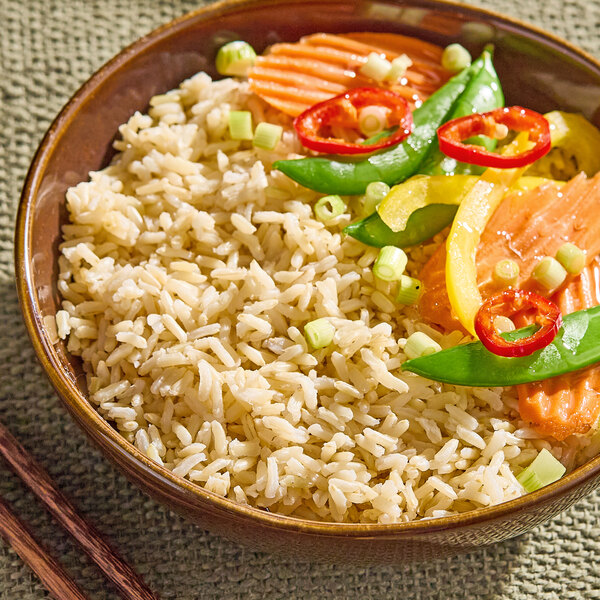 A bowl of cooked long grain brown jasmine rice served with vegetables.