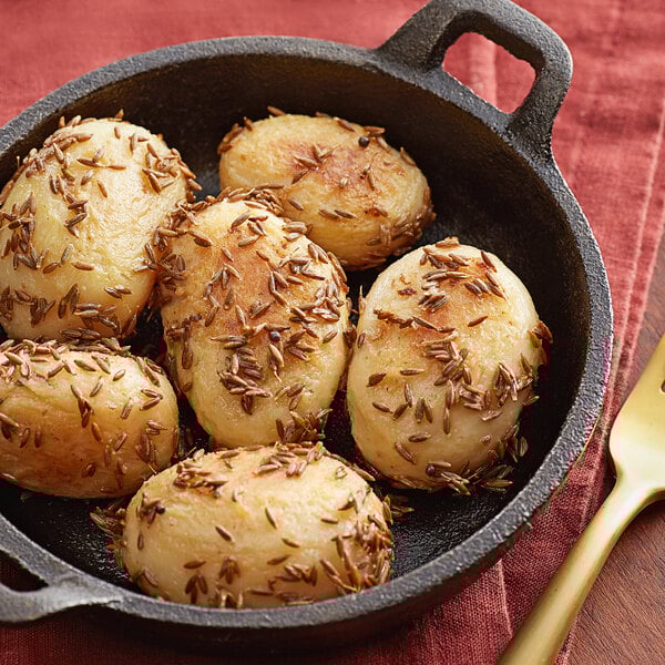 A pan of potatoes with Regal Cumin Seeds on top.