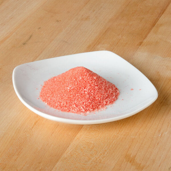 A small white plate with a pile of pink salt on it.