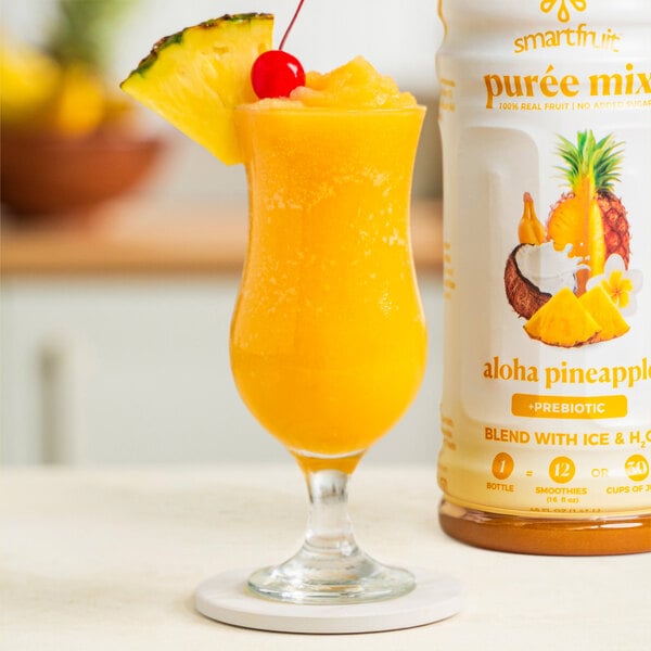 A glass of orange liquid made with Smartfruit Aloha Pineapple Puree.