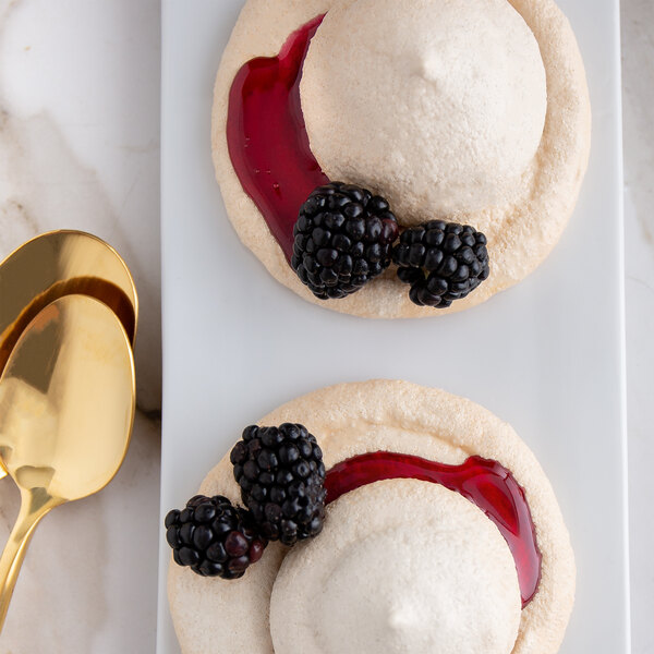 A white dessert with blackberries and Fabbri Amarena cherry sauce.