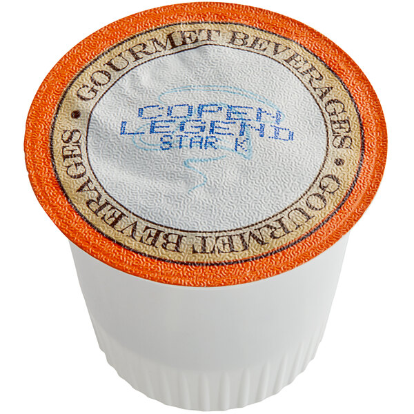 A white Caffe de Aroma coffee cup with an orange and black label.
