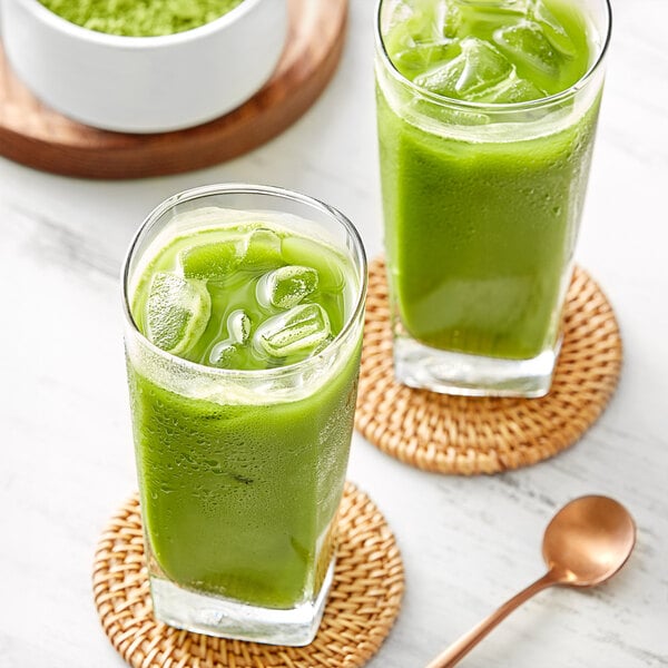 A glass of green liquid with ice and a spoon of Jade Leaf Ceremonial Barista Edition Matcha Powder.