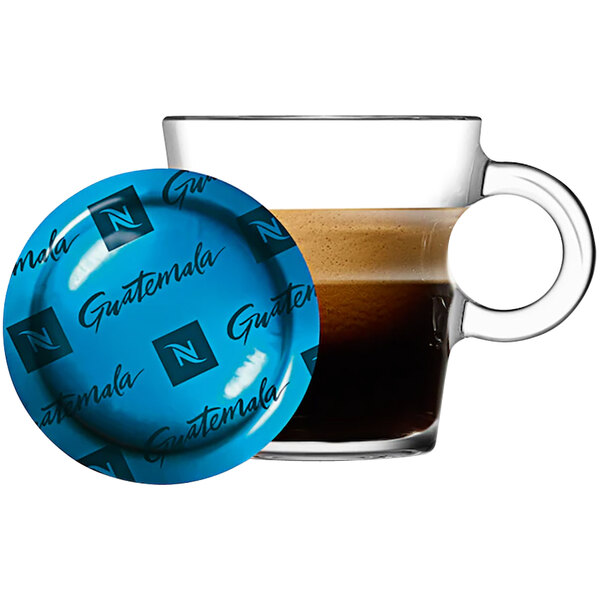 A glass cup of brown Nespresso Guatemala coffee on a saucer.