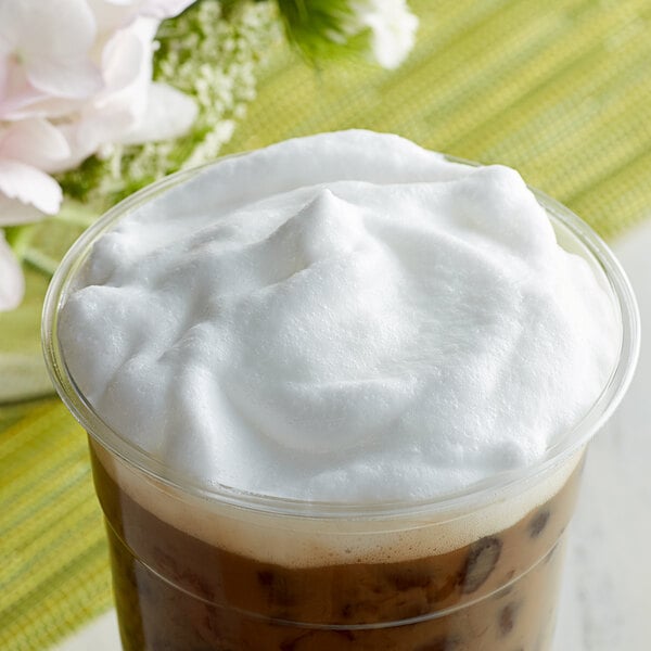 A cup of coffee with whipped cream on top.